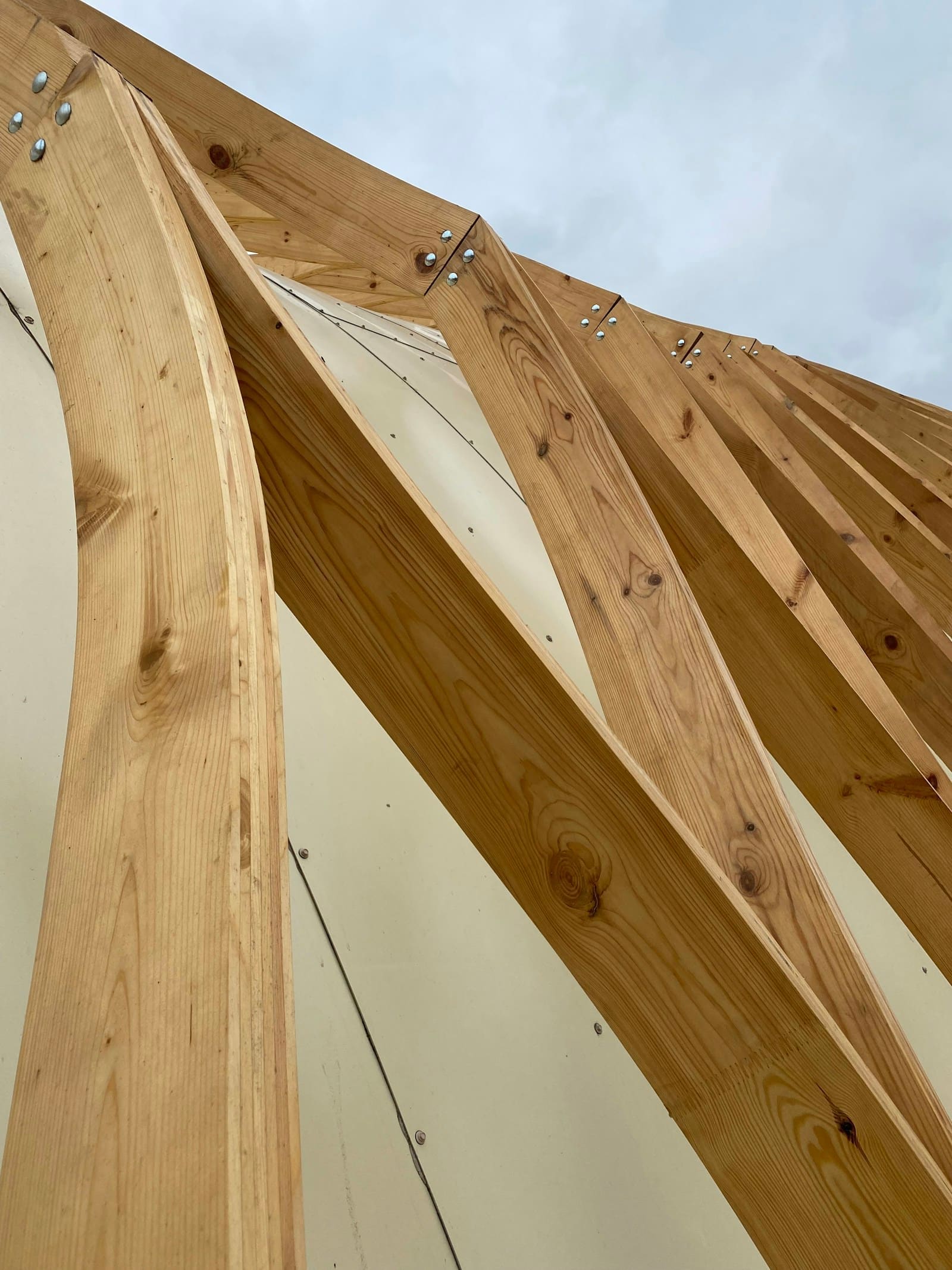 Estrutura de vigamento de madeira clara em obra — fotografia de referência da aplicação, não da obra da Madeireira Oliveira.
