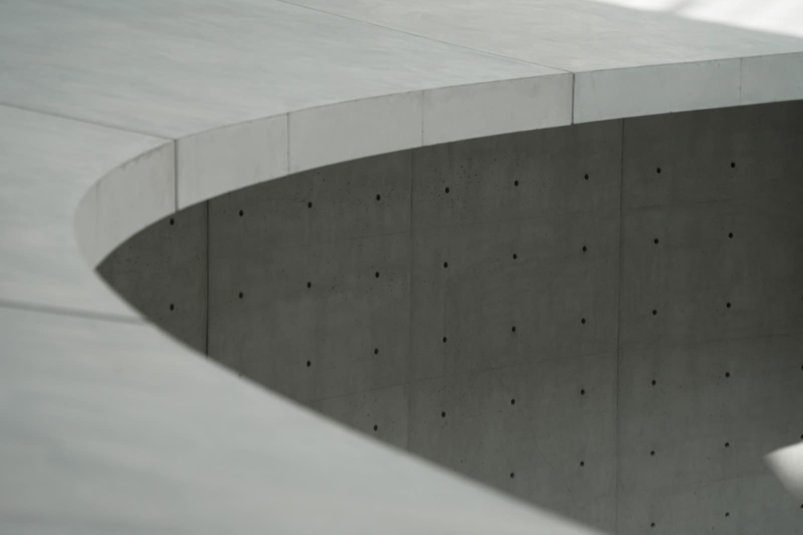 Concreto aparente com marcas de espaçadores de fôrma — resultado típico obtido com fôrma reutilizável; fotografia de referência, não da obra da Madeireira Oliveira.